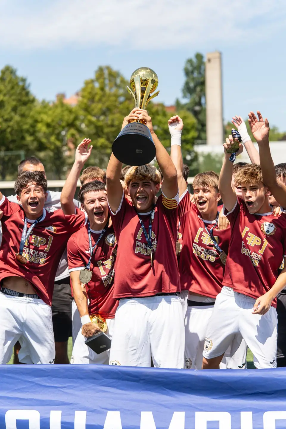 Équipe de jeunes footballeurs soulevant le trophée des champions