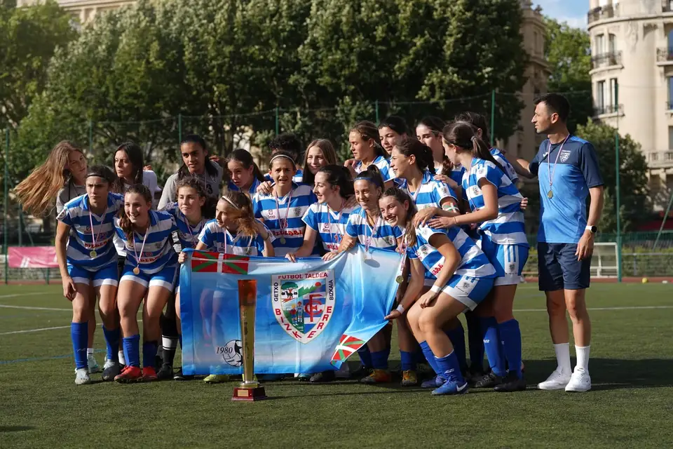 Photo officielle d’une équipe féminine avec sa bannière et son trophée