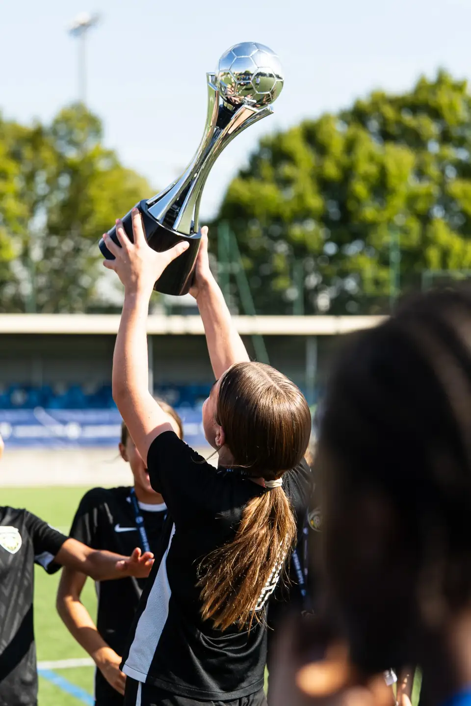 Joueuse soulevant un trophée argenté à bout de bras