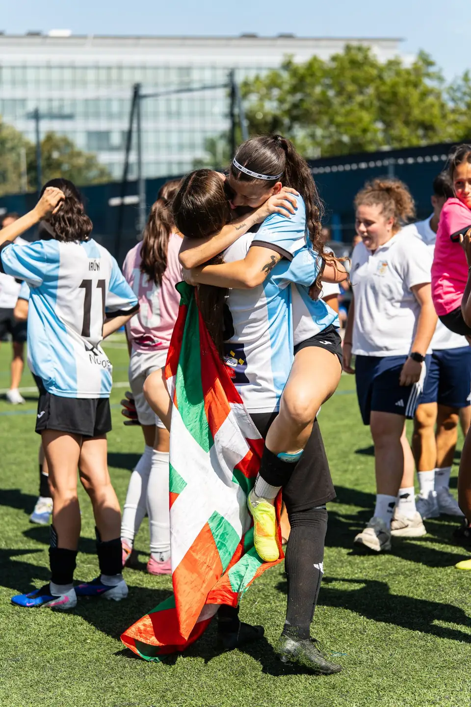 Deux joueuses s’enlaçant, drapeau basque déployé