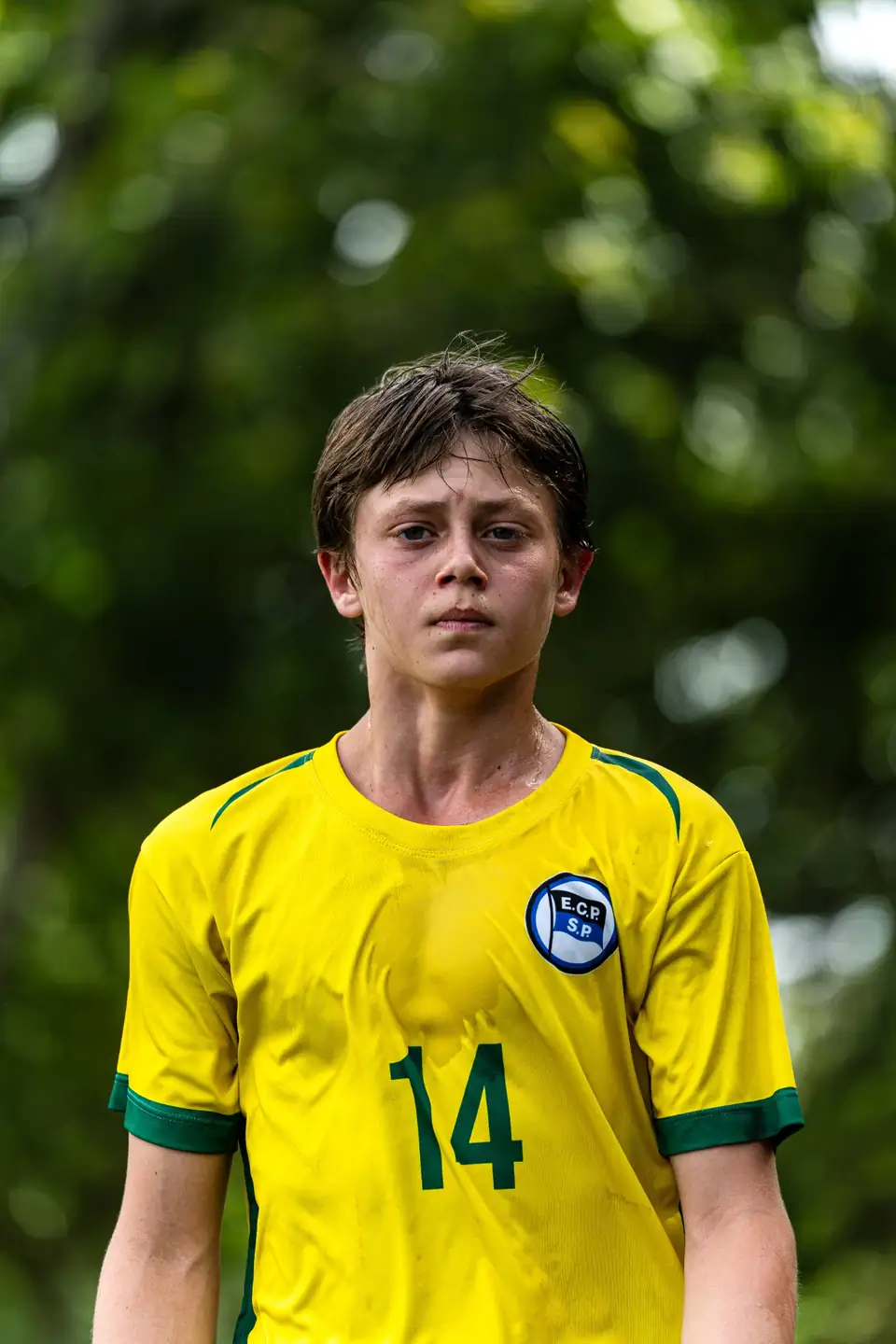Portrait d’un jeune joueur concentré en maillot jaune et vert